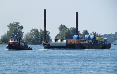 Small but powerful tug Seahound "leashed" to a huge barge and headed to Little Current, Ontario, Canada.