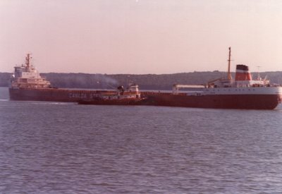 Simcoe aground in the St. Mary's near Lime Island. Tug Wilfred Cohen working to free her.
