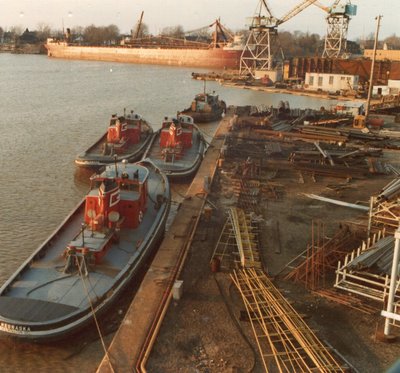 "G" tugs Nebraska, Delaware, and California with the Sylvania in the background. American Shipbuilding, Lorain.