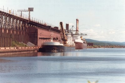 Sam Laud finishing up loading taconite and the Johnstown unloading coal at the power plant at Erie Mining Co., Taconite Harbor.