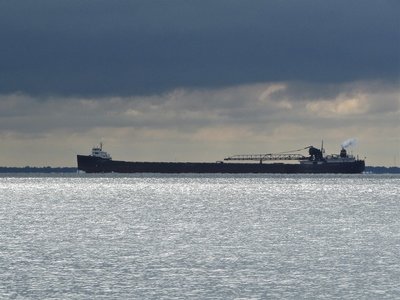 Lee A. Tregurtha (Marquette) under threatening skies but sailing over an expanse of sun-bathed water off Ft. Gratiot County Park.