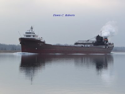 Lee A. Tregurtha (Silver Bay) is reflected in relatively calm waters off Stag Island.