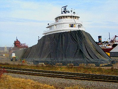 The bow of the Kaye E. Barker under a tarp while being sandblasted &amp; painted