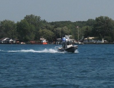 Don't know why, but this patrol boat came down the river with lights flashing, made a fast turn, and stopped in a group of jet skiers and boaters.  (I asked about the orange boat across the river.  It may be a private supply boat for doing waterfront repair work.)